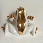 Figurine de grenouille couchée en porcelaine blanche, éclats d’or sur le buste
