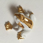 Figurine de grenouille en porcelaine blanche, vue du dessous avec aplats dorés