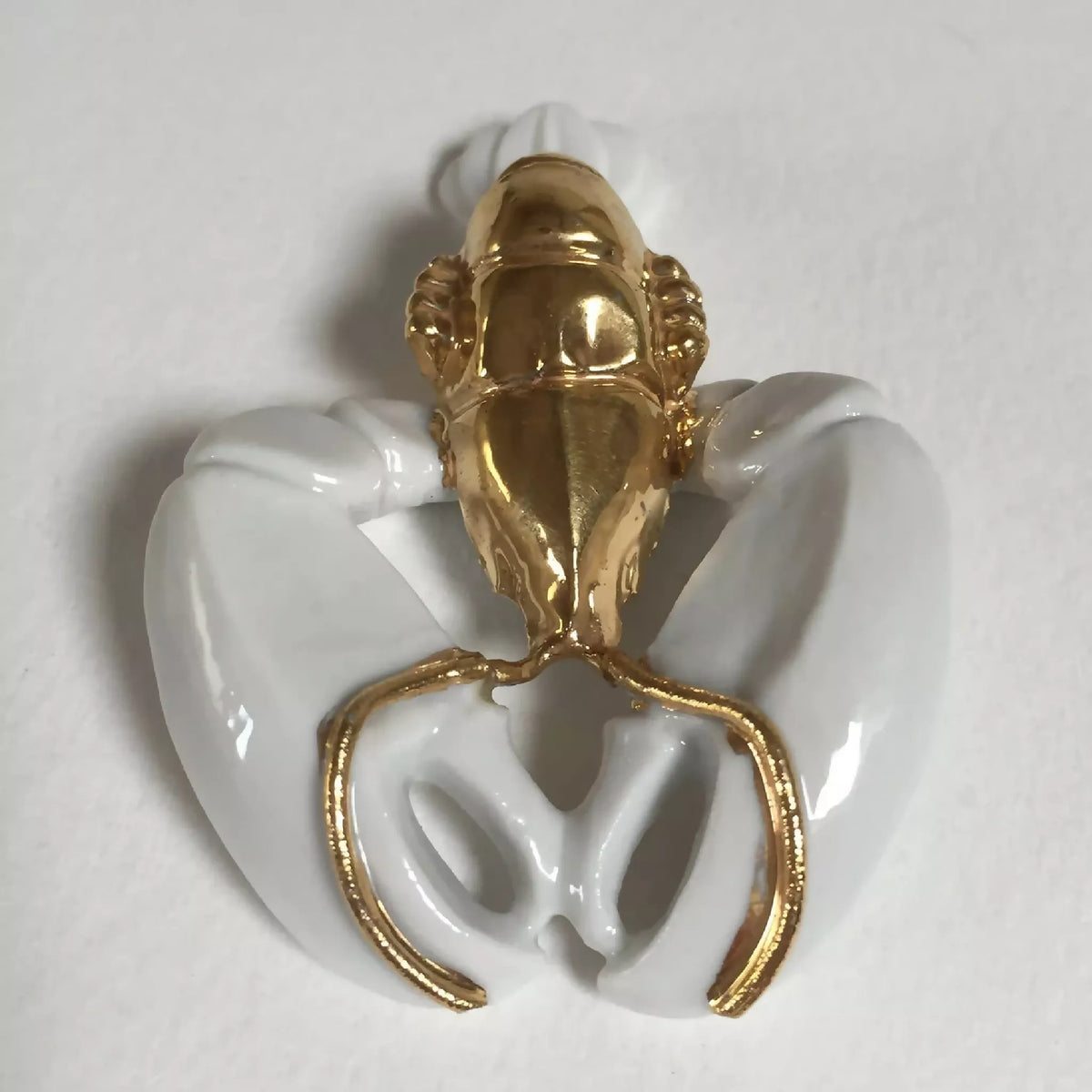 Porte-couvert homard tête dorée et pinces blanches, détail de l’ouverture.