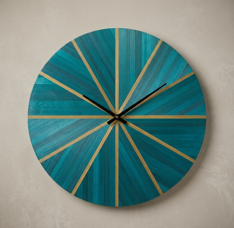Horloge murale ronde en marqueterie de paille bleutée et dorée, aiguilles noires.