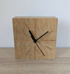 Horloge de bureau carrée en chêne clair, face avant, aiguilles noires et repères colorés.