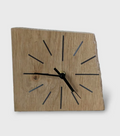 Horloge de bureau en chêne clair, cadran à repères noirs et bleutés, aiguilles dorées.
