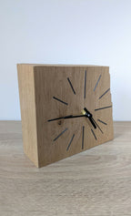 Horloge de bureau en chêne, cadran avec repères noirs et bleutés, aiguilles dorées.