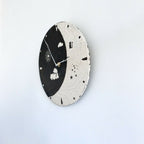 Horloge murale ronde noir et ivoire, cadran Jour et Nuit en vue inclinée, aiguilles et motifs