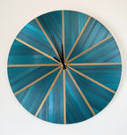 Horloge murale ronde en marqueterie paille bleu-vert et doré, cadran rayé, aiguilles noires