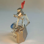 Sculpture en fils d’acier, couple sur socle doré, cœur rouge et assise bleue visibles