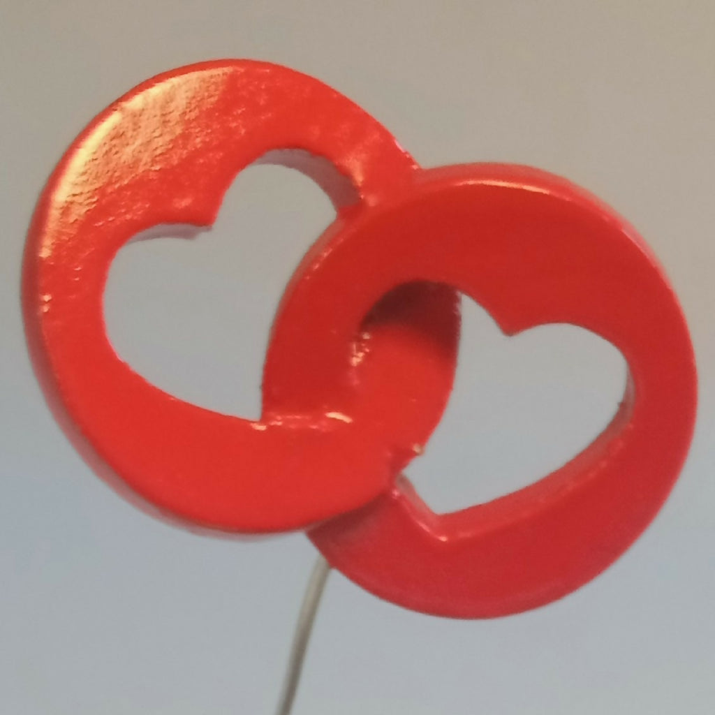 Cœur rouge en relief avec deux formes de cœurs blancs, fixé sur une tige