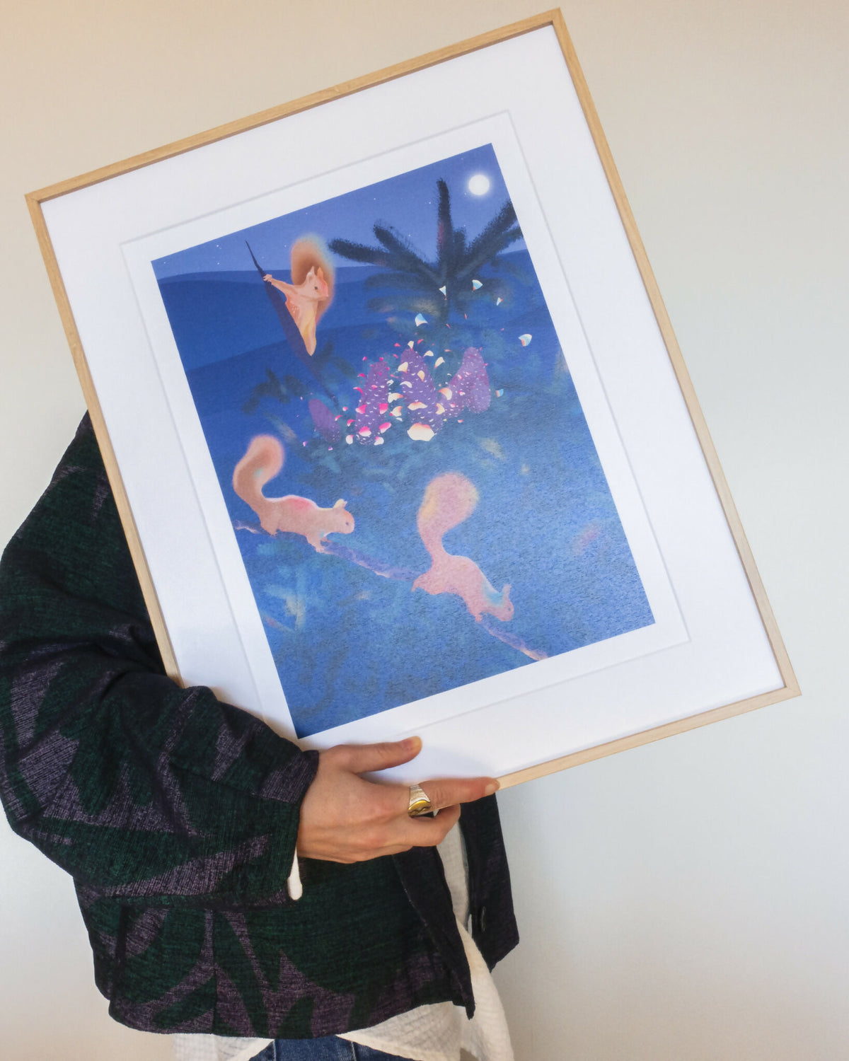 Affiche L'éclosion en cadre bois, illustration bleue avec créatures orange et fleurs roses.