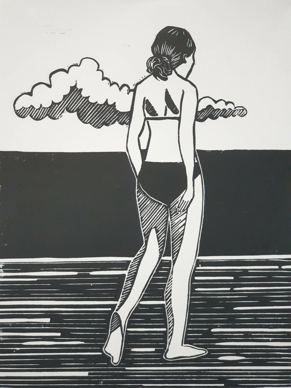 Affiche noir et blanc encadrée, femme debout jouant de la guitare sous des nuages.