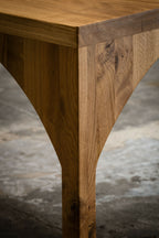 Angle de table en bois : pied incliné et bord du plateau, gros plan.