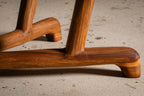 Table en bois massif, gros plan d’un coin avec pied sculpté et base moulurée.