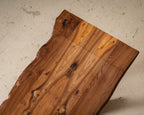 Table en bois massif, plateau rectangulaire avec nœuds et reflets du veinage.