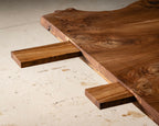Table en bois massif, vue dessous du piètement avec ouvertures et traverses.