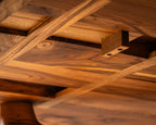Table en bois massif, détail de l’entrecroisement des traverses sous le plateau.