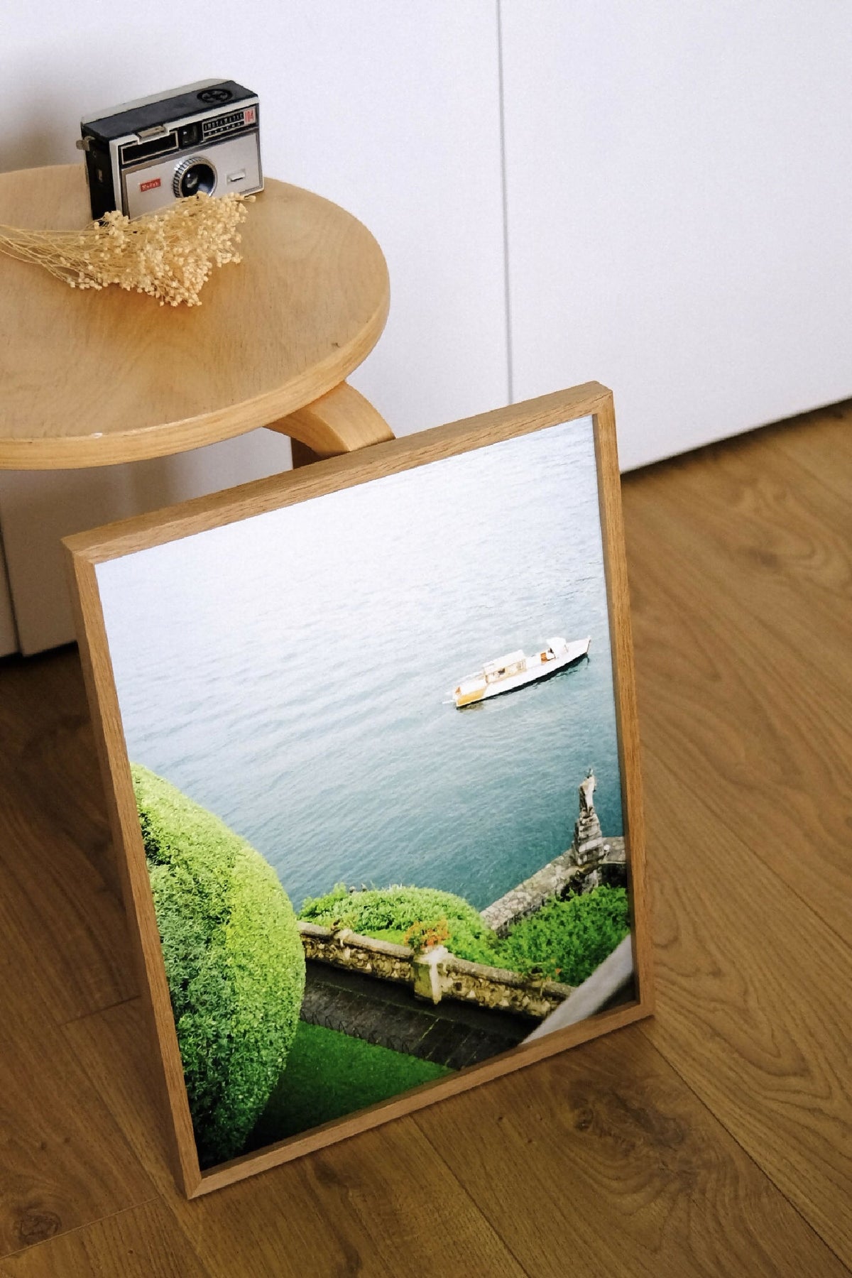 Affiche encadrée du Lac de Côme : bateau sur l’eau et talus verdoyant