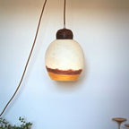 Lampe baladeuse TERRE DE SIENNE avec abat-jour en verre beige et base en bois sombre.