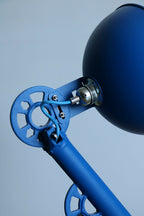 Lampe bleue : bras et douille métallique près de l’abat-jour