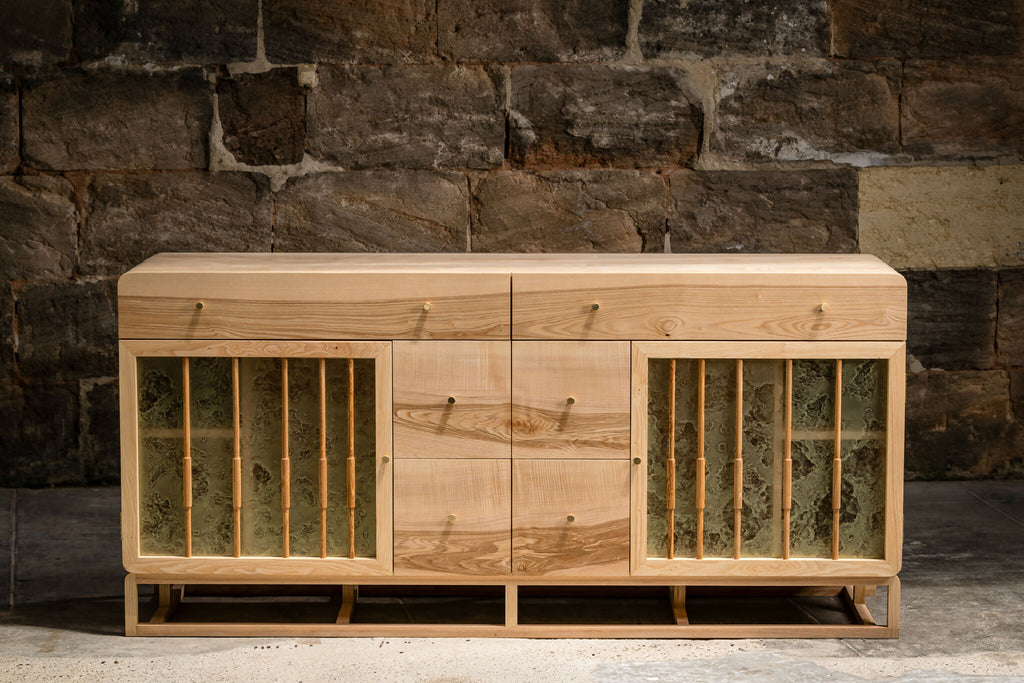 Buffet en bois clair avec portes à lames verticales, façade symétrique