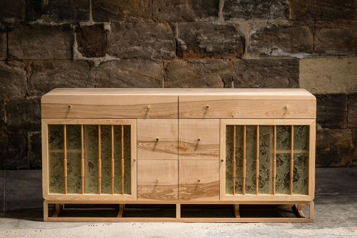 Buffet en bois clair avec portes à lames verticales, façade symétrique