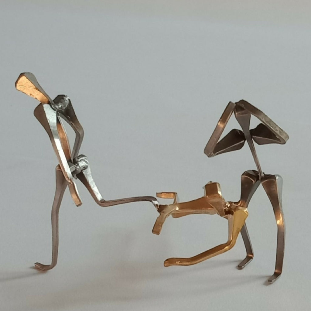 Deux figurines de joueurs de handball métalliques, poses opposées, tons dorés