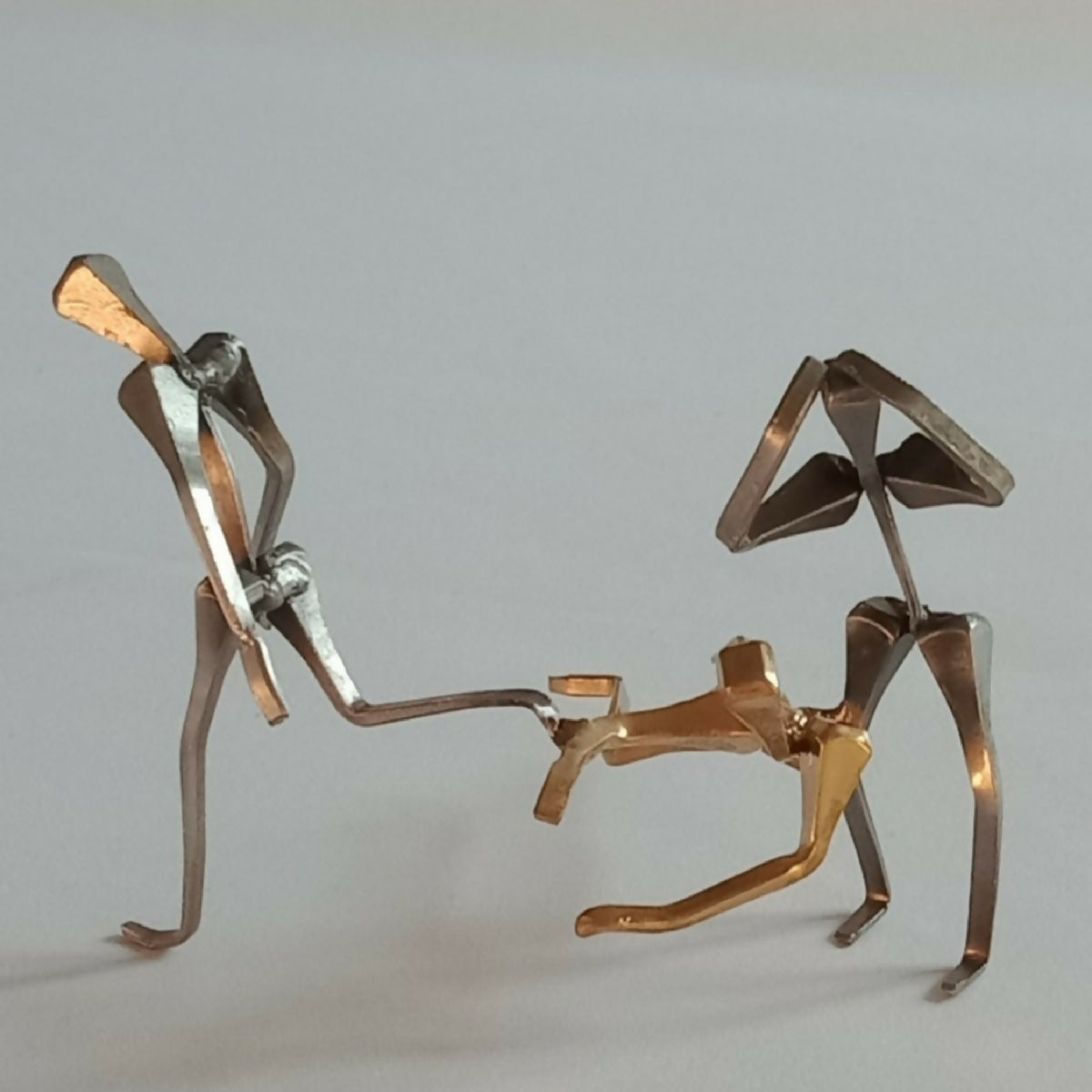 Deux figurines de joueurs de handball métalliques, poses opposées, tons dorés