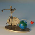 Statuette de golfeur en métal doré, globe bleu-vert et cœur rouge, sur socle