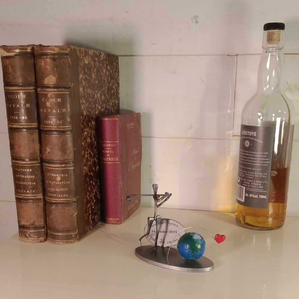 Statuette de golfeur en métal doré sur socle, globe bleu-vert et cœur rouge