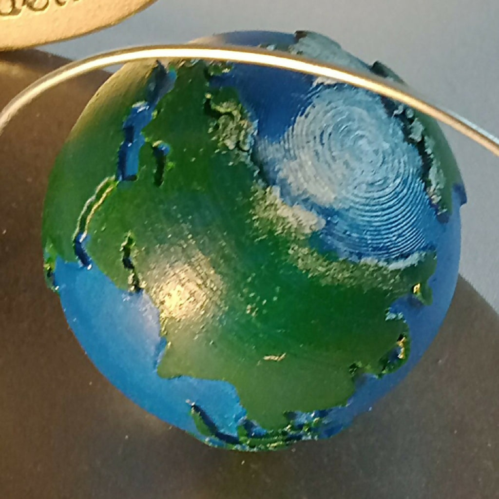 Globe décoratif bleu-vert avec contour argenté et tige métallique