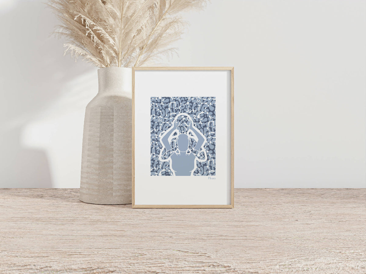 Tirage A4 encadré, motif abstrait bleu texturé, posé près d’un vase beige.