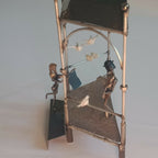 Manège décoratif avec figurines, barre arquée et oiseau en blanc en suspension.
