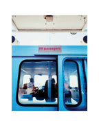 Photo encadrée, gros plan sur bus bleu avec panneau « 69 passagers »
