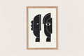 Linogravure encadrée : visages abstraits noirs, lignes blanches, fond clair.