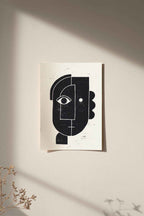 Linogravure encadrée, visage abstrait noir sur fond clair, affiche rectangulaire