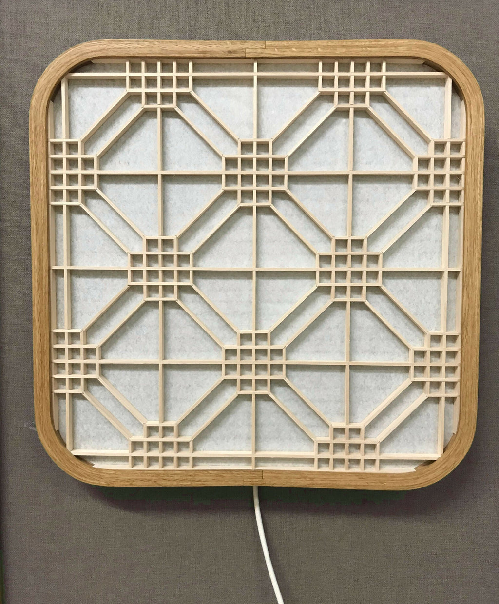 Décoration murale lumineuse Hotaru, structure en bois et grille géométrique interne.