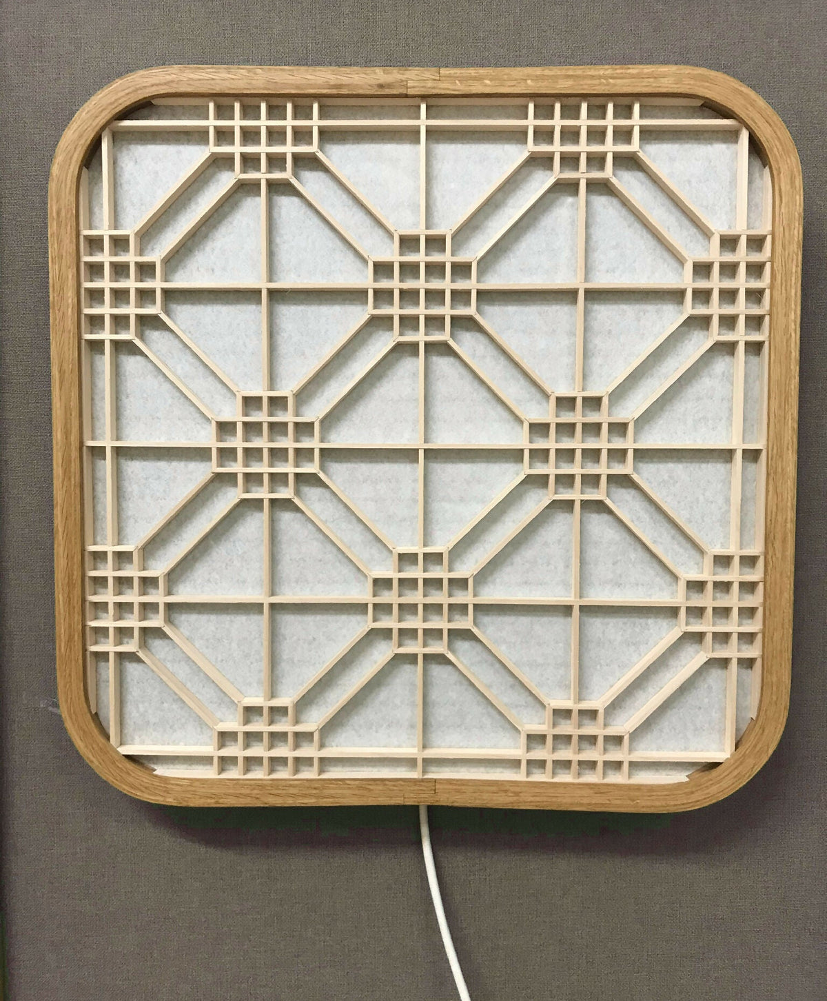 Décoration murale lumineuse Hotaru, structure en bois et grille géométrique interne.