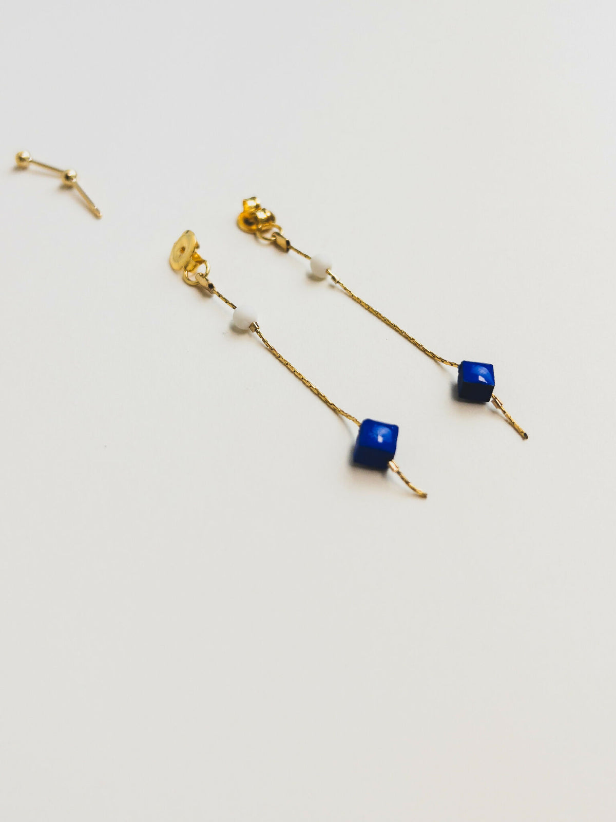 Boucles d’oreilles pendantes dorées avec perles bleu royal sur chaînes fines