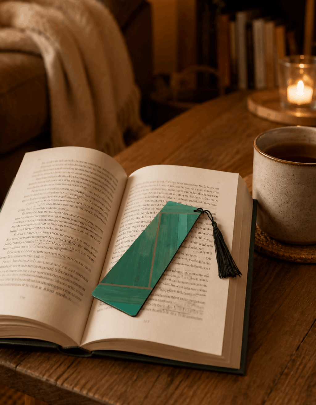 Marque-page en paille marquetée vert, pompon noir, dans un livre ouvert