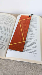 Marque-page orange en marqueterie de paille, ficelle noire nouée sur un livre