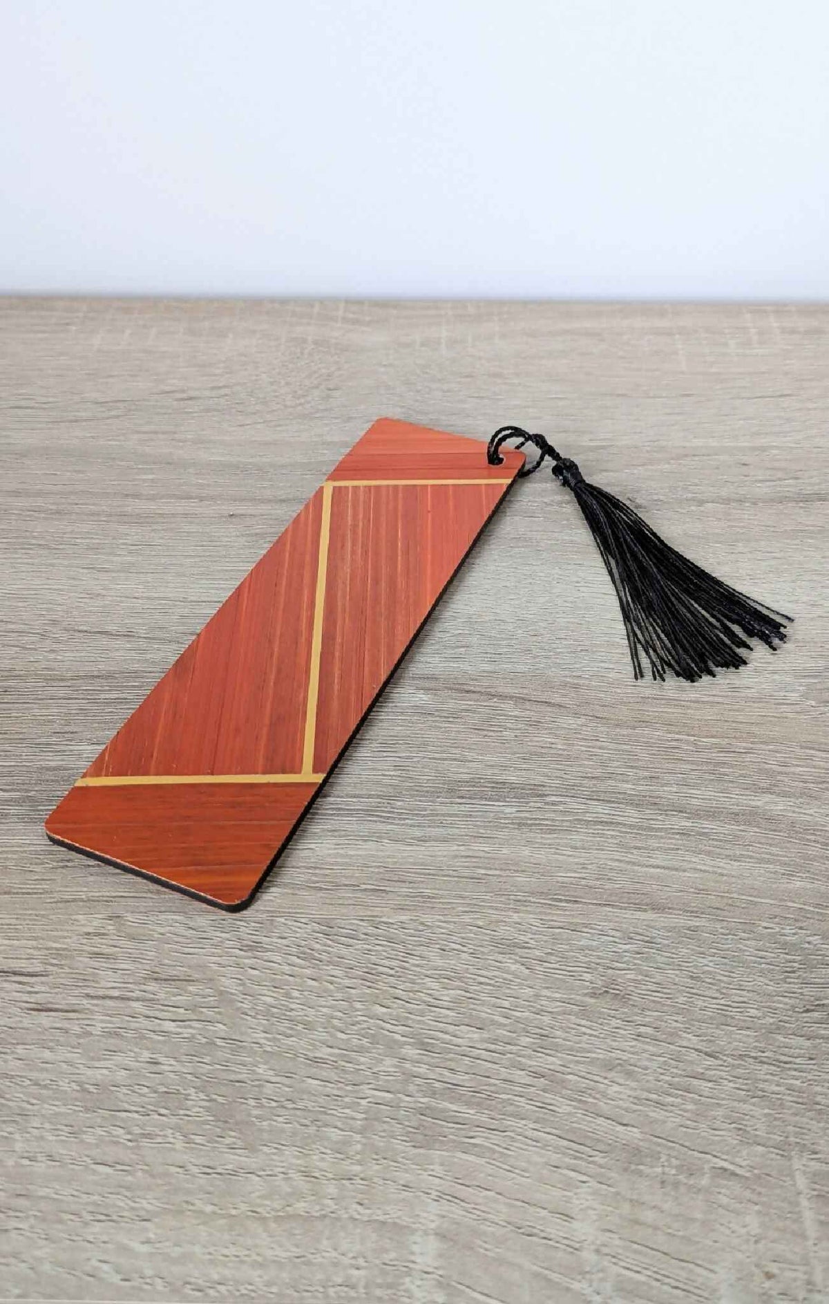 Marque-page orange en marqueterie de paille, pompon noir sur ficelle
