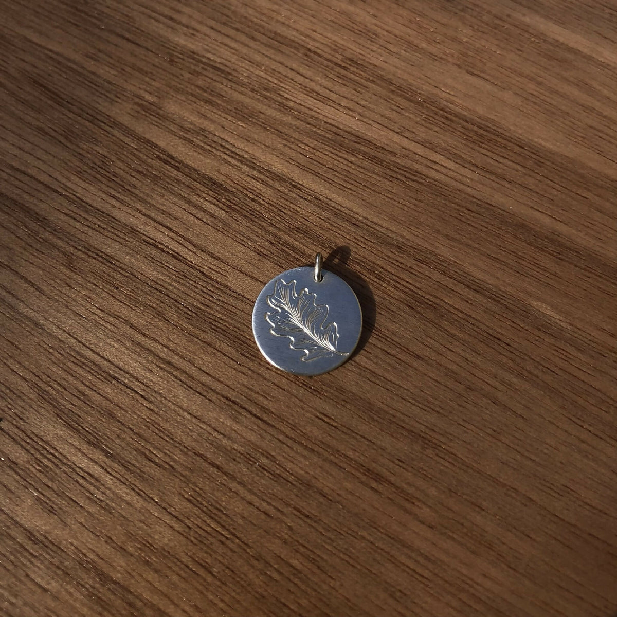 Médaille ronde en argent 925 avec gravure feuille de chêne, bélière et tige.