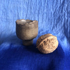 Petit pot en terre cuite sombre avec pièce détachée à côté