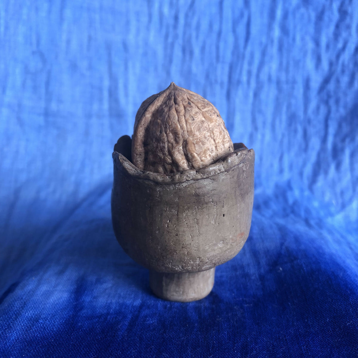 Petit pot en terre cuite sombre, texture sculptée, ouvert sur le dessus