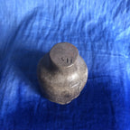Petit pot en terre cuite sombre, dessous gravé, finition patinée