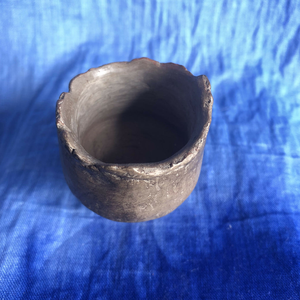 Petit pot en terre cuite sombre, vue de l’ouverture intérieure