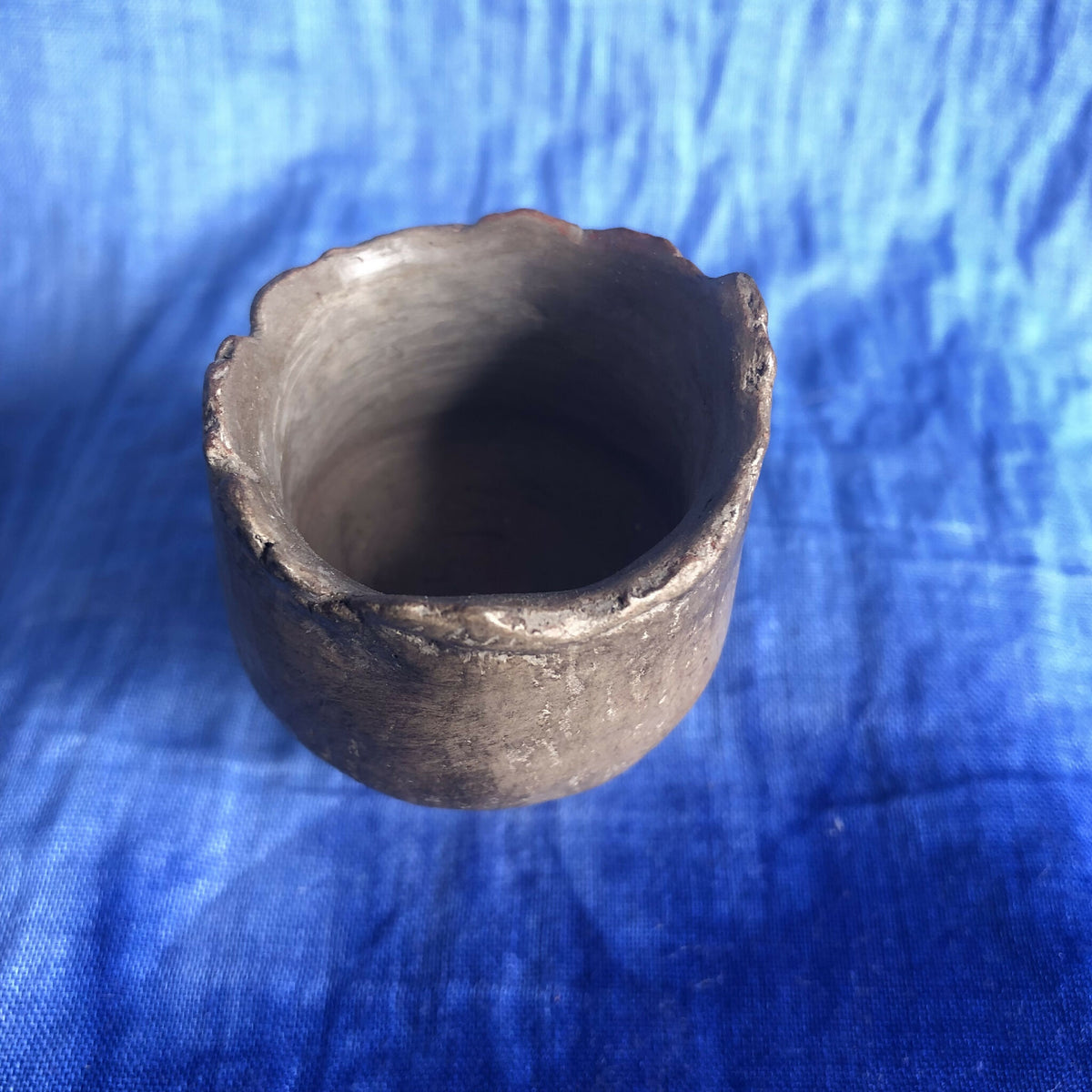 Petit pot en terre cuite sombre, vue de l’ouverture intérieure