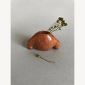 Mini vase en forme de coquillage brun cuivré, avec herbes sèches en bouquet.