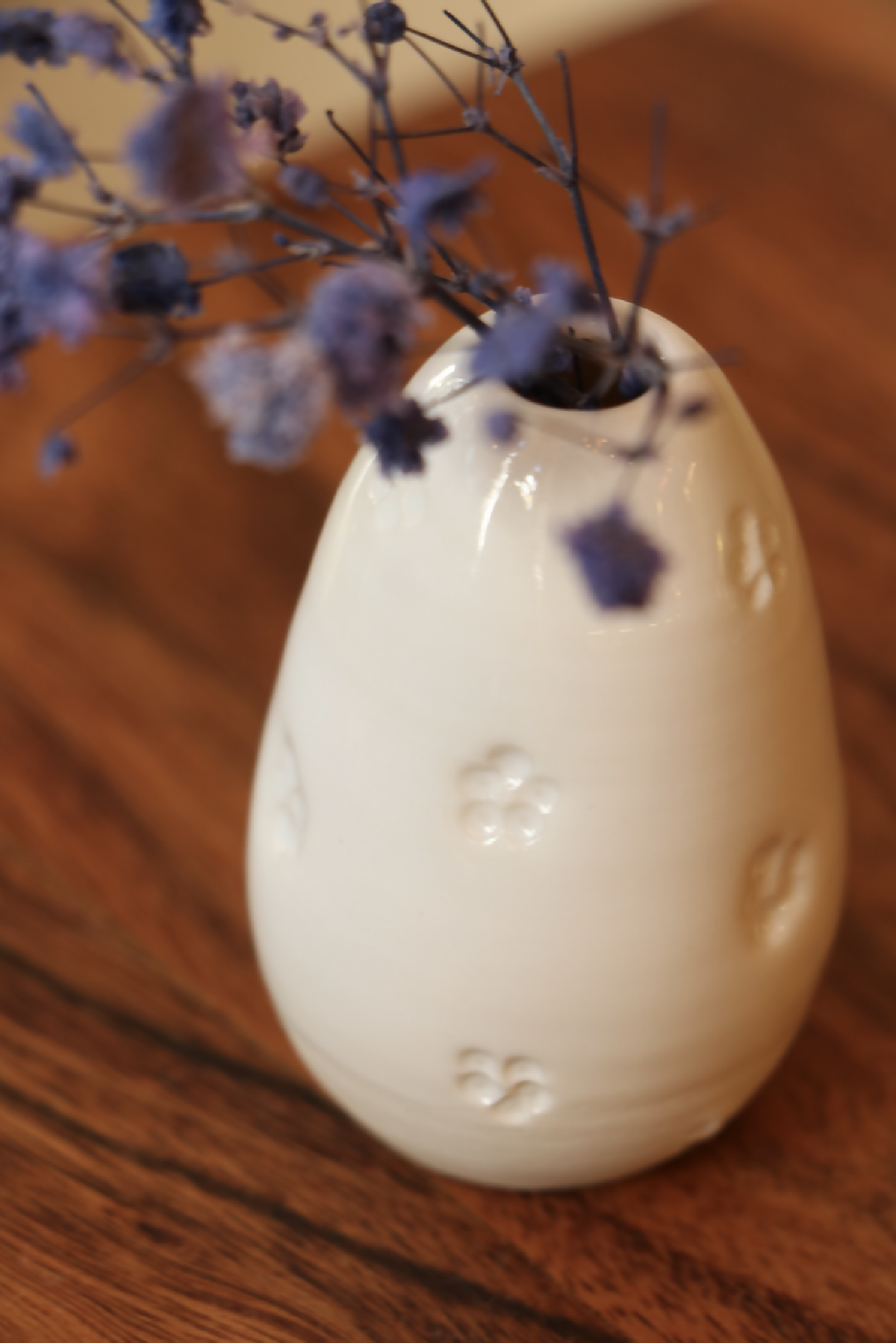 Mini-vase en porcelaine blanc, forme goutte, gros plan sur le motif en relief