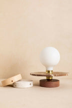 Applique murale avec socle rond brun, ampoule blanche et douille dorée, éclairage