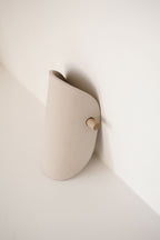 Applique murale en céramique beige, forme arrondie, fixation avec bouton en bois