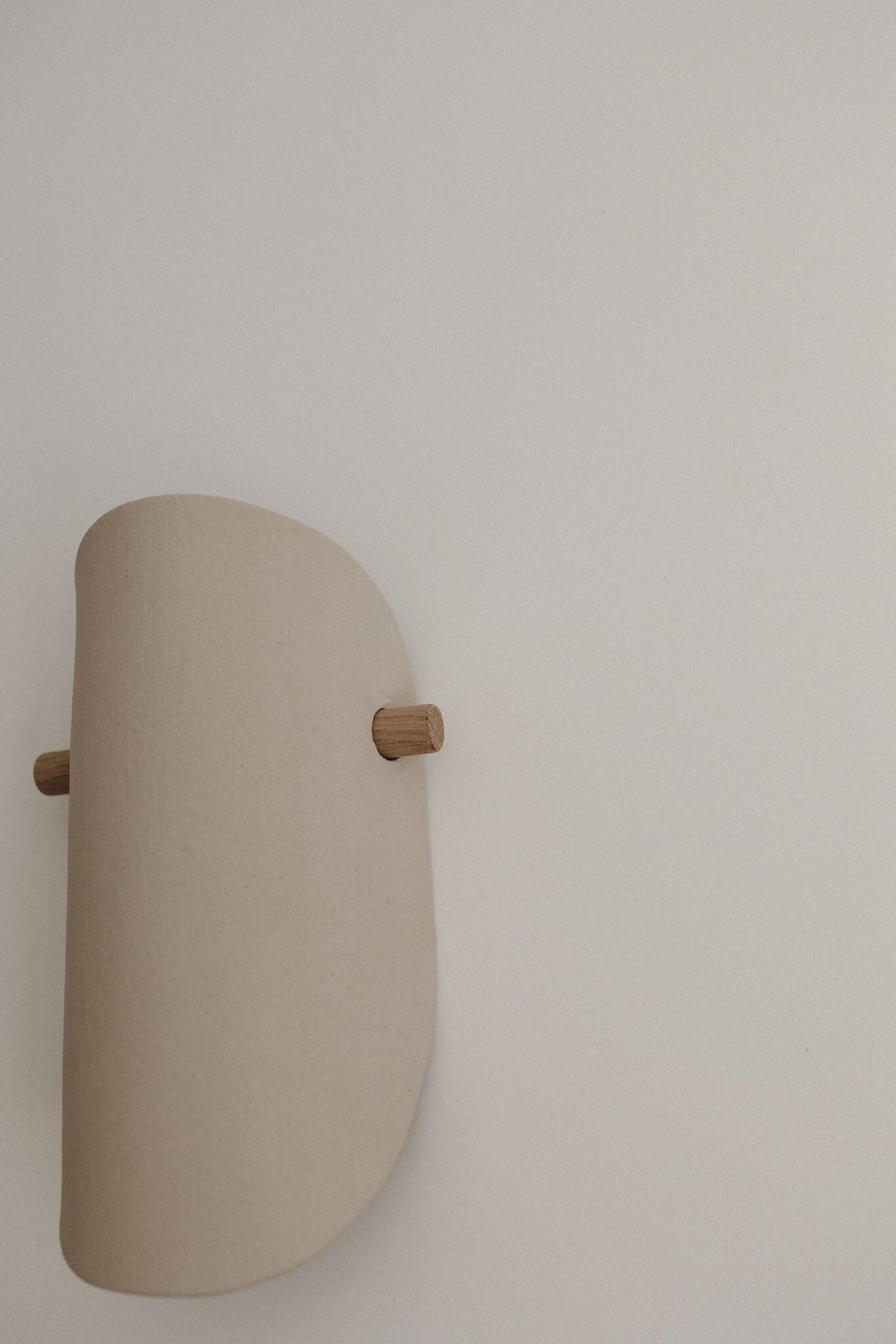Applique murale en céramique beige, vue de côté, fixation en bois
